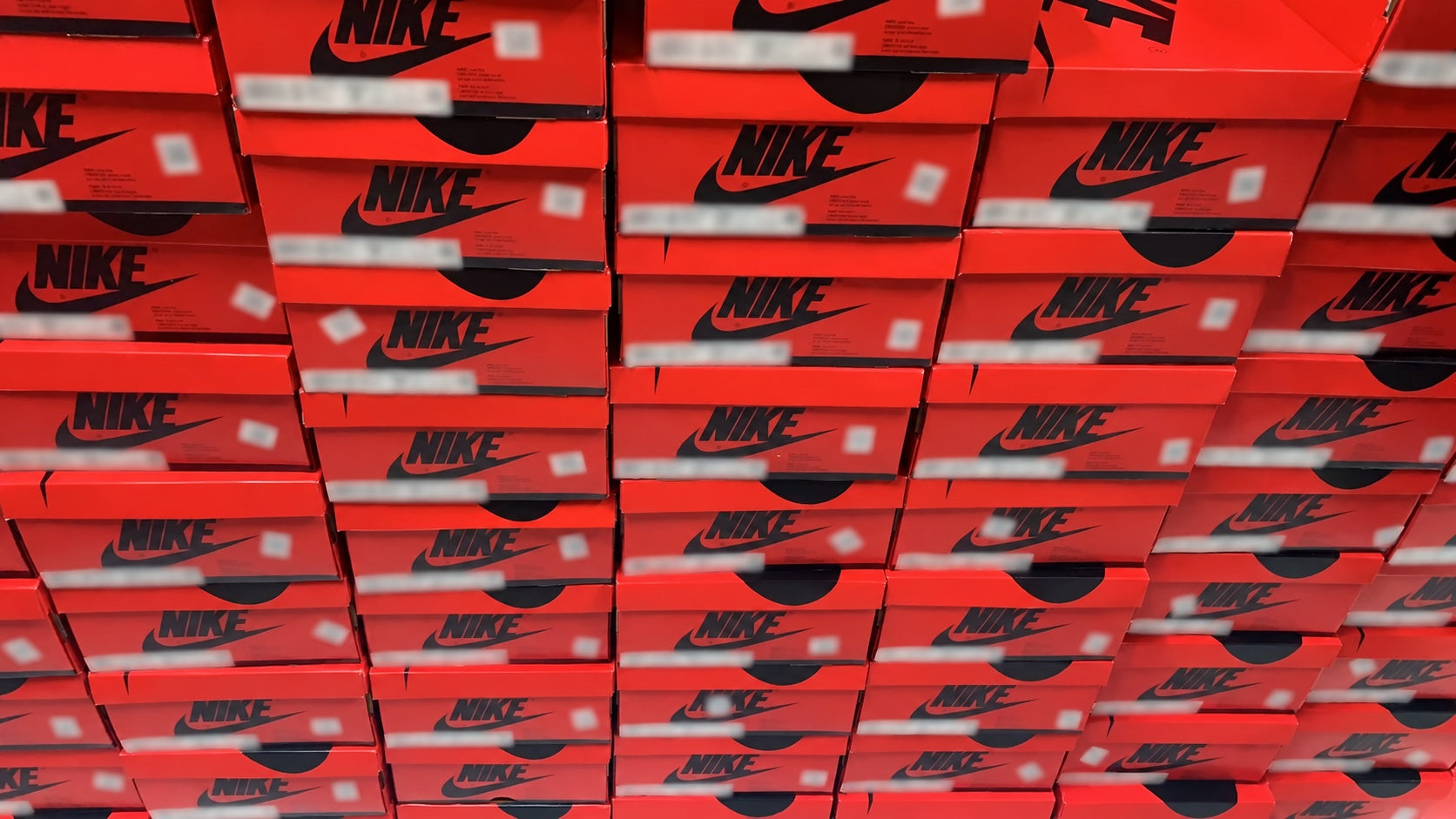Stacks of red Nike shoe boxes ready for order processing