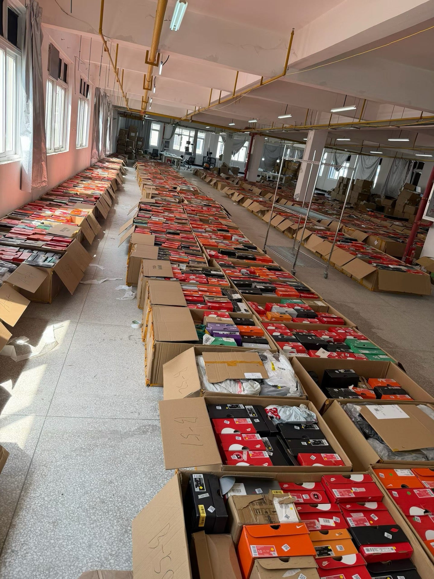 Staged footwear inventory arranged in open cartons for order sorting and verification