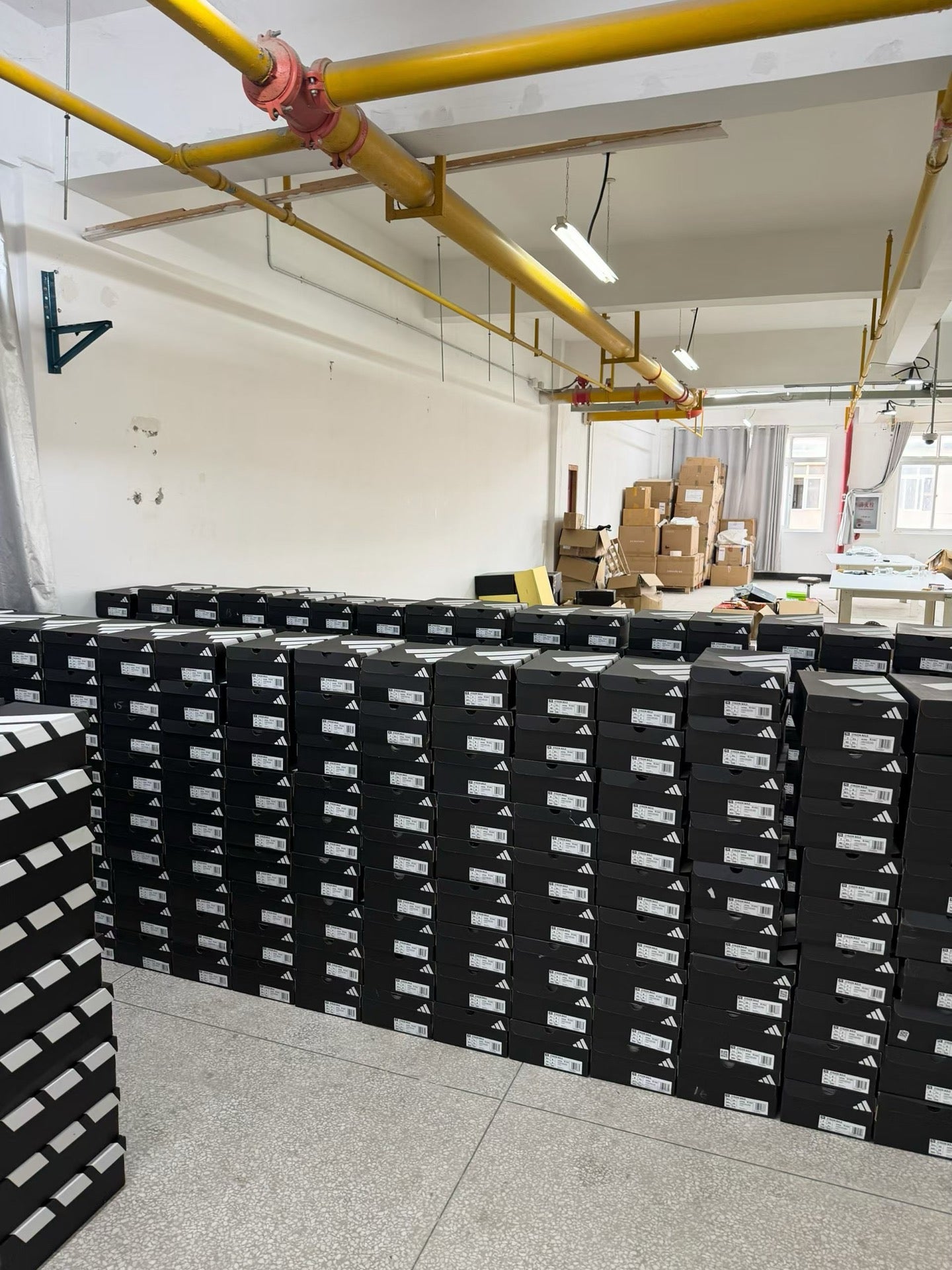 Stacks of Adidas footwear inventory inside a China warehouse