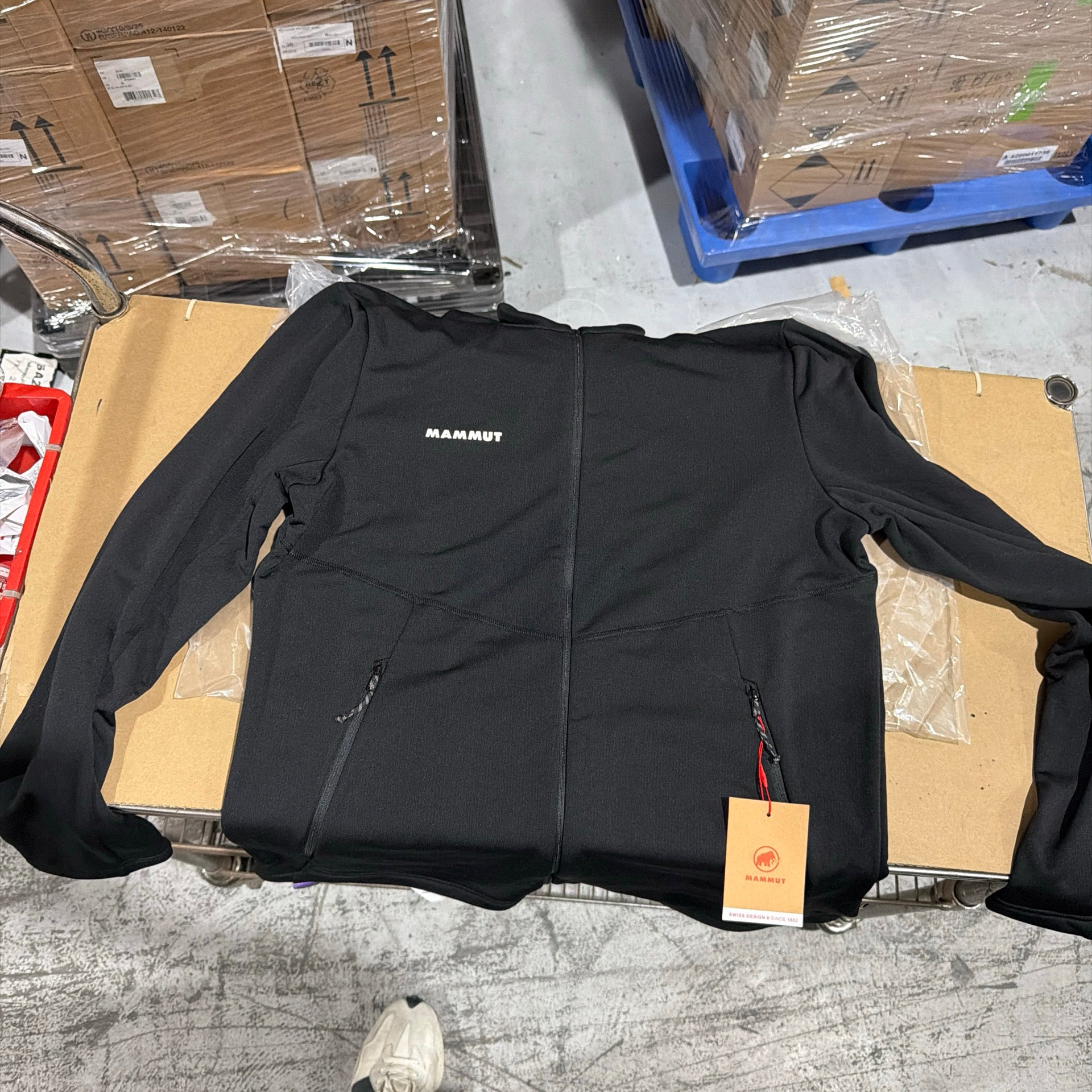 A Mammut jacket laid out for product inspection in a warehouse